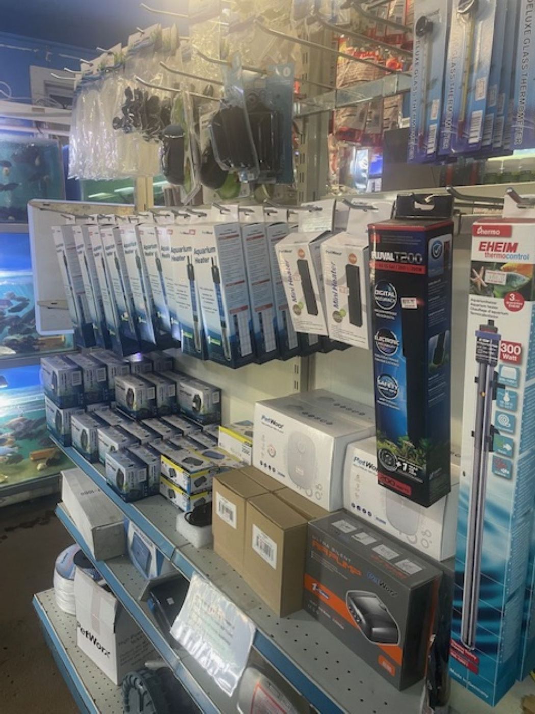 Retail shelving unit stocked with various aquarium equipment, including heaters, filters, and small electronic devices.