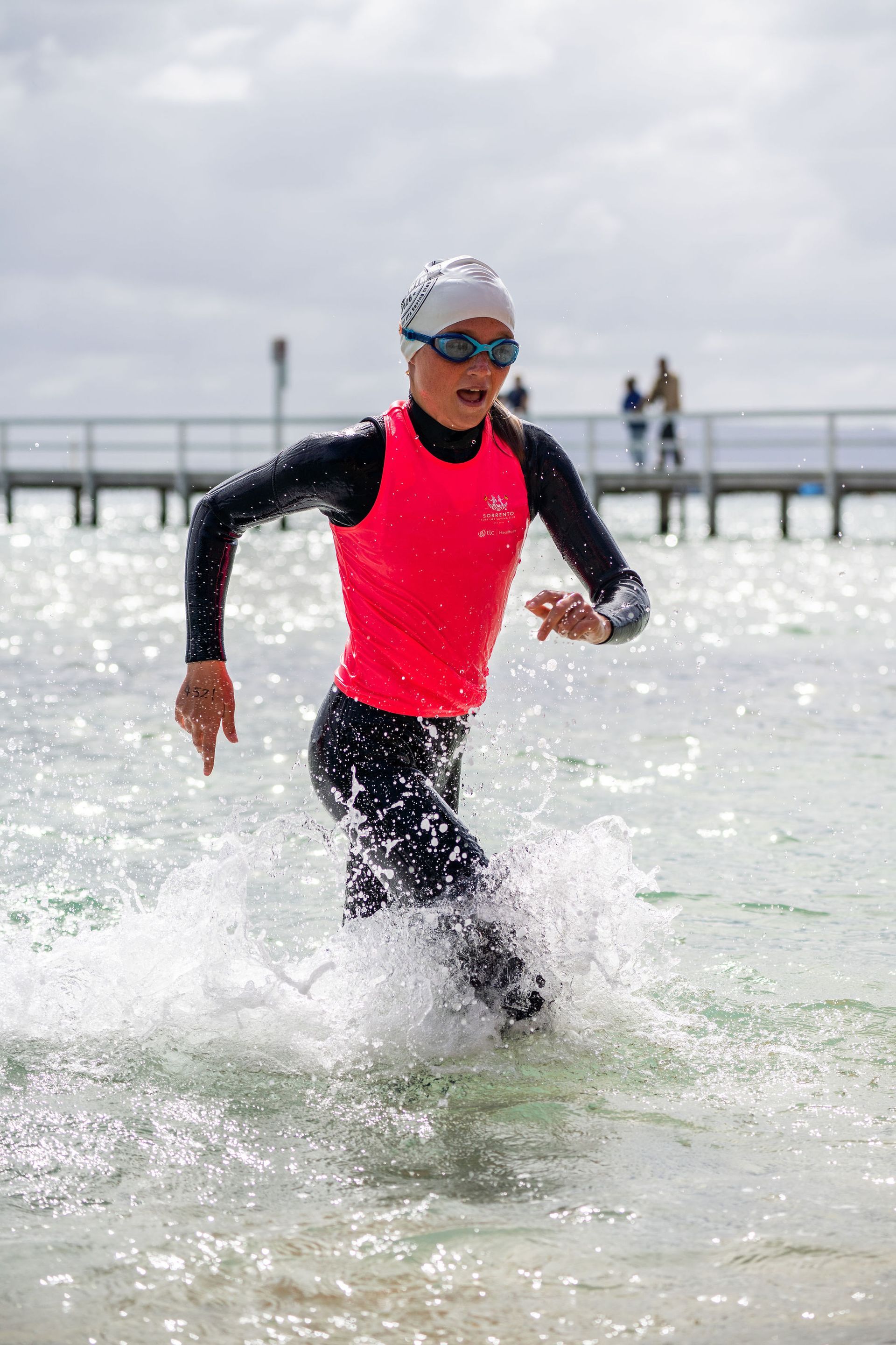 Sorrento Nipper in the pink vest and cap running out of the water