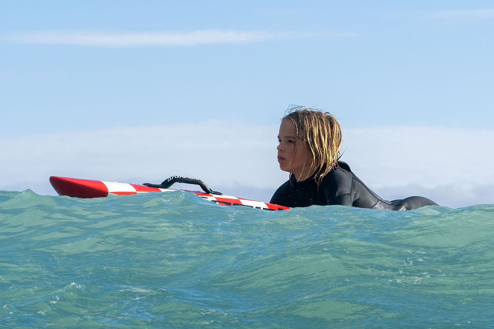 Young Sorrento SLSC member paddling a nipper board in the surf