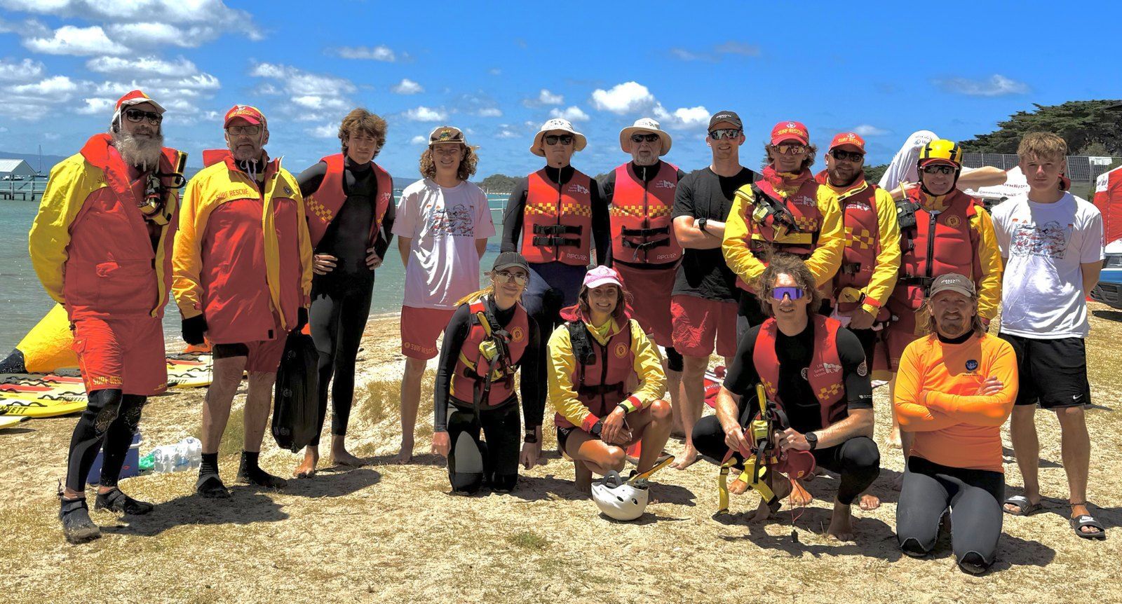 The Bay Swim water safety and volunteer team gathered on the foreshore in wetsuits and hi-vis.