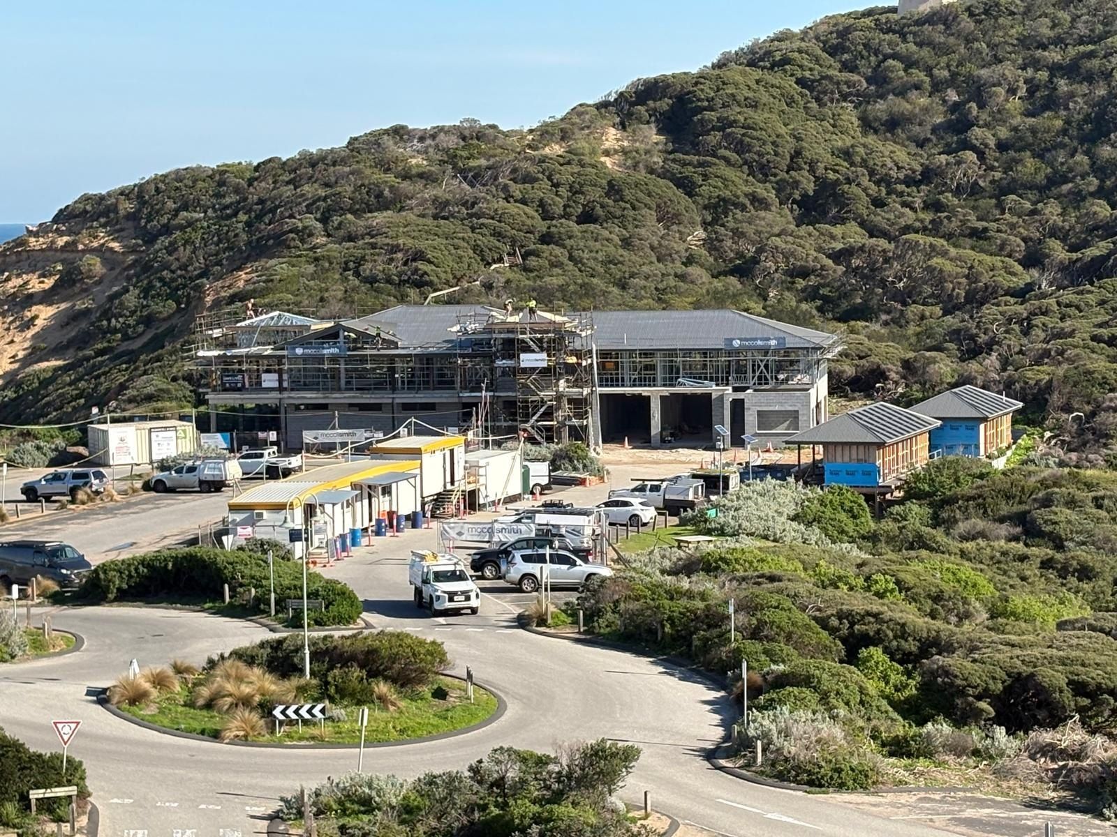 The new Sorrento clubhouse under construction, scaffolded and roofed, set into the dune above the car park.