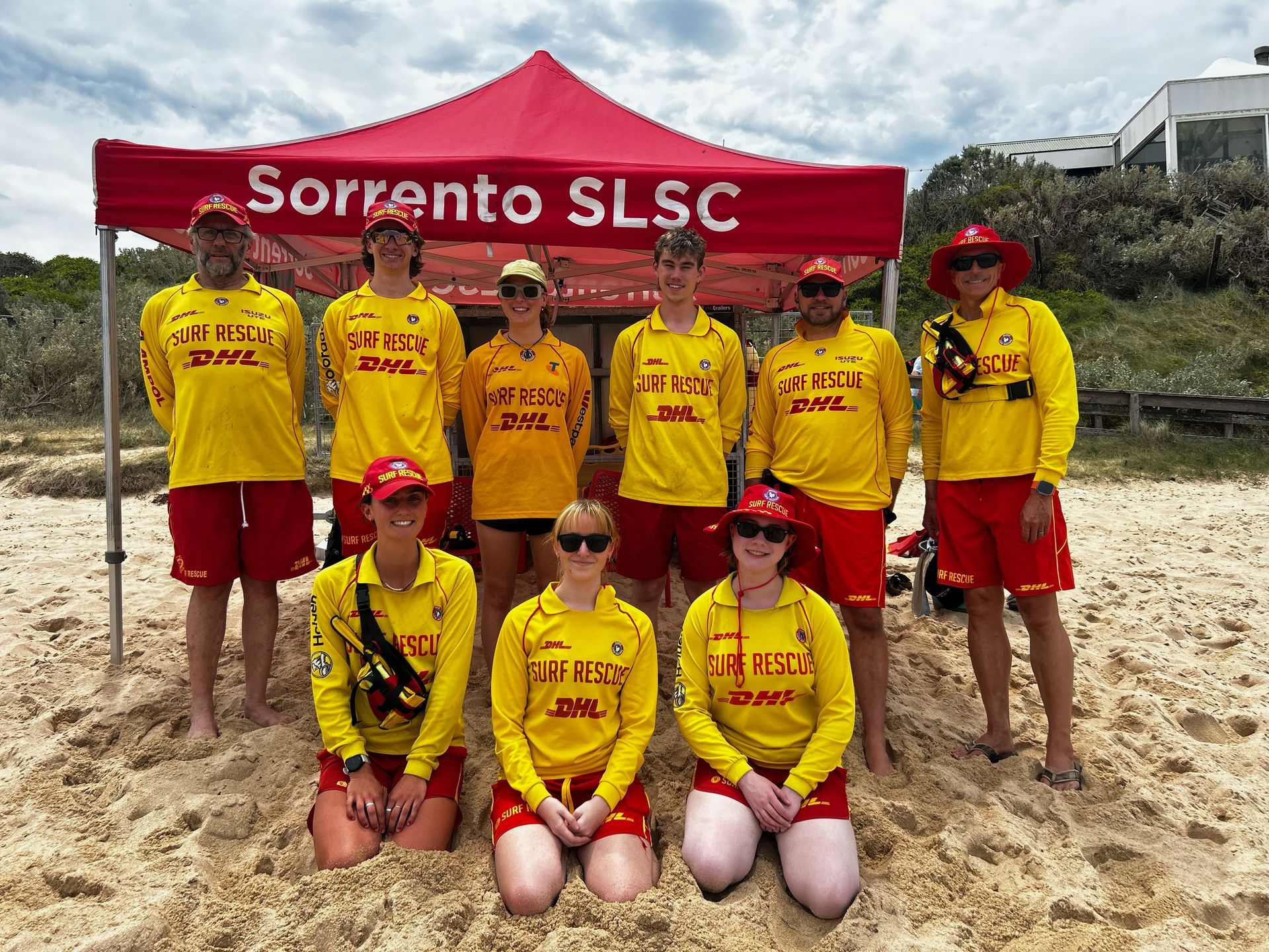 Sorrento SLSC patrol members in red and yellow under the club gazebo on the beach