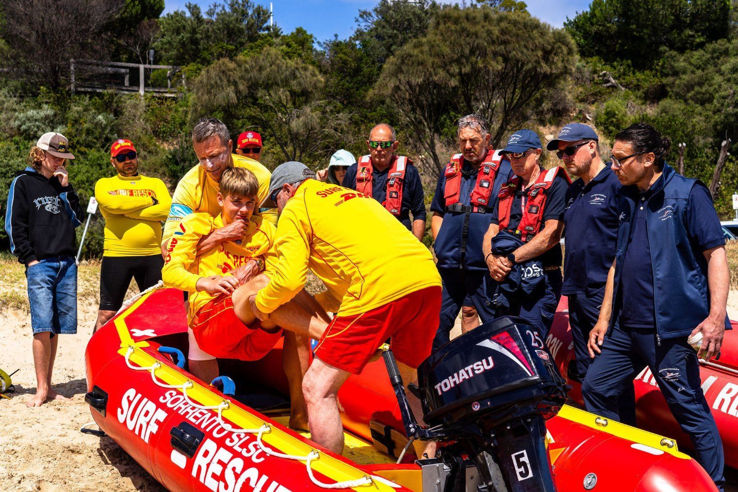 Lifesavers and emergency services personnel working together around an inflatable rescue boat during Exercise Warreeny.