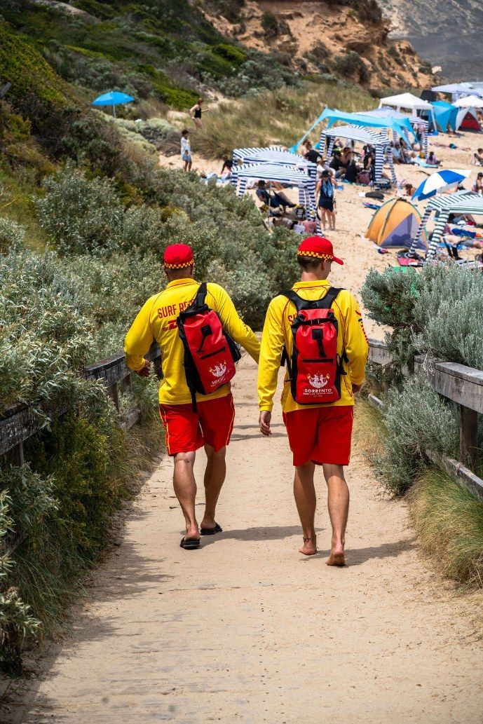 Two patrolling members in yellow and red walking the track down to Sorrento back beach.