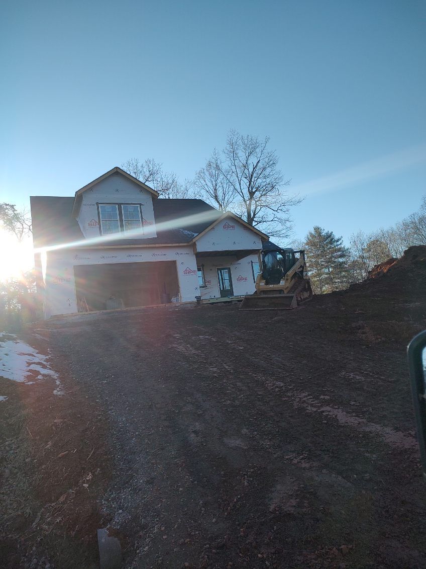 Suburban house at sunrise with bright sun glare and a leaf-covered driveway