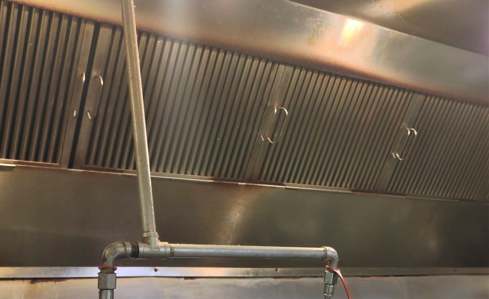 A close up of a stainless steel exhaust hood in a kitchen.