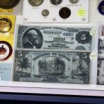 A display case filled with coins and a dollar bill.