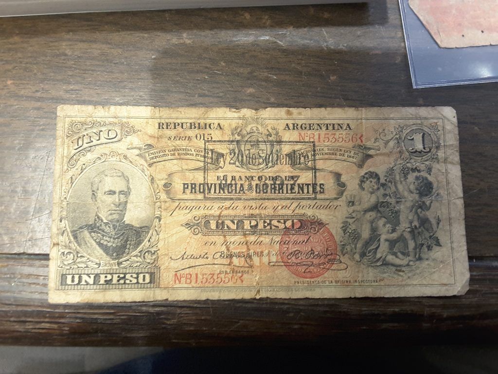 An old currency note is sitting on a wooden table.