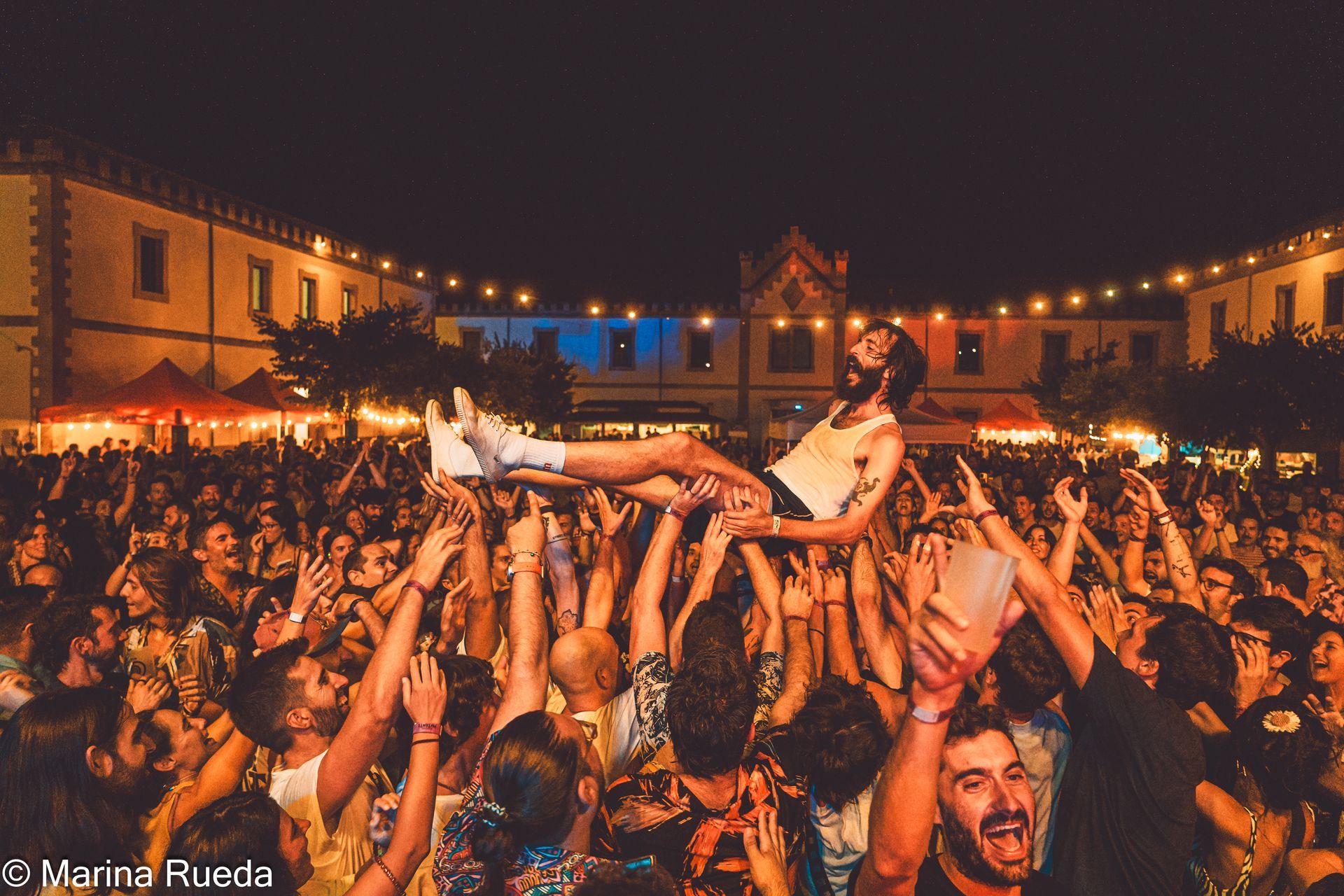 Una mujer es levantada en el aire por una multitud de personas en un concierto.