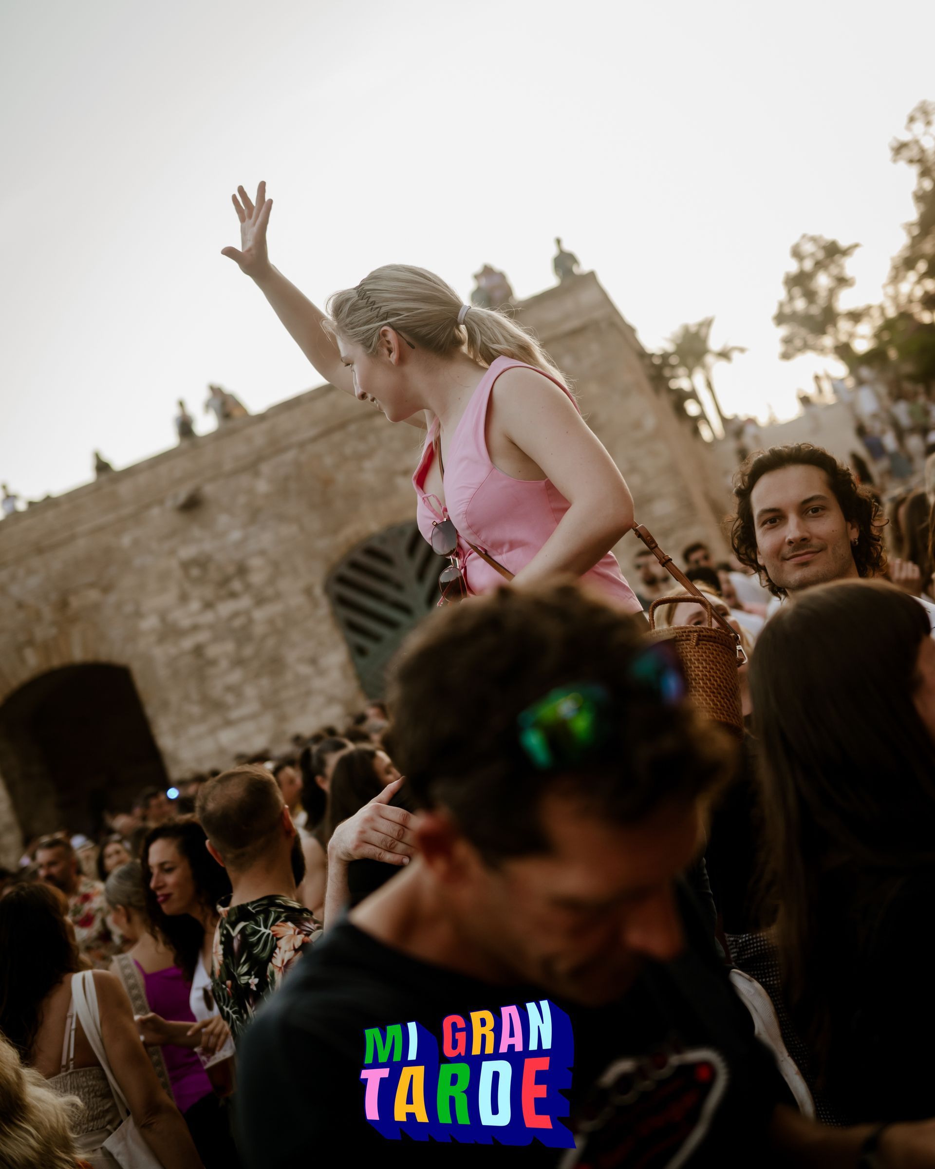 Una mujer con una blusa rosa es llevada por un hombre con una camisa de Mi Gran Tahoe.