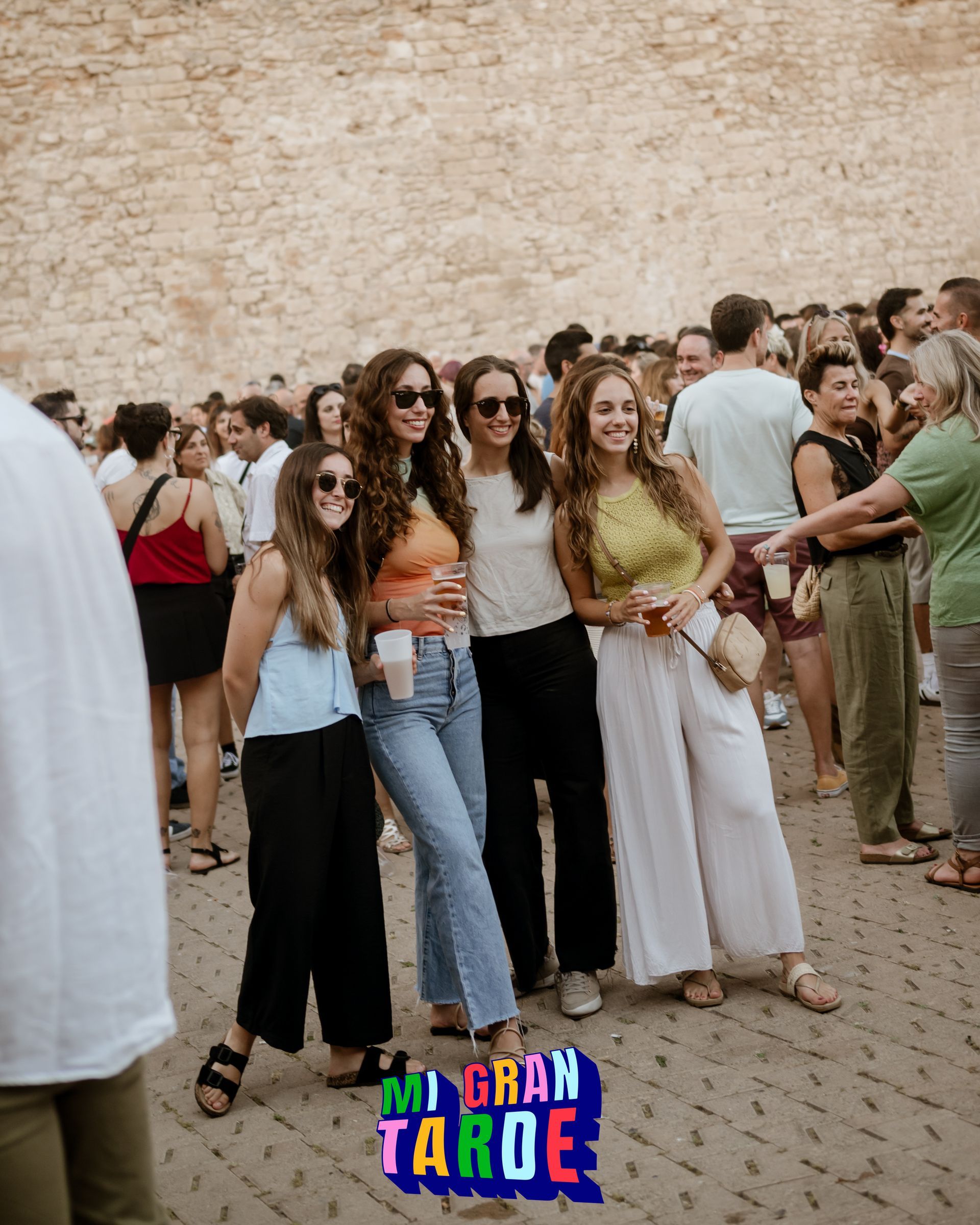 Un grupo de mujeres posa para una fotografía entre una multitud.
