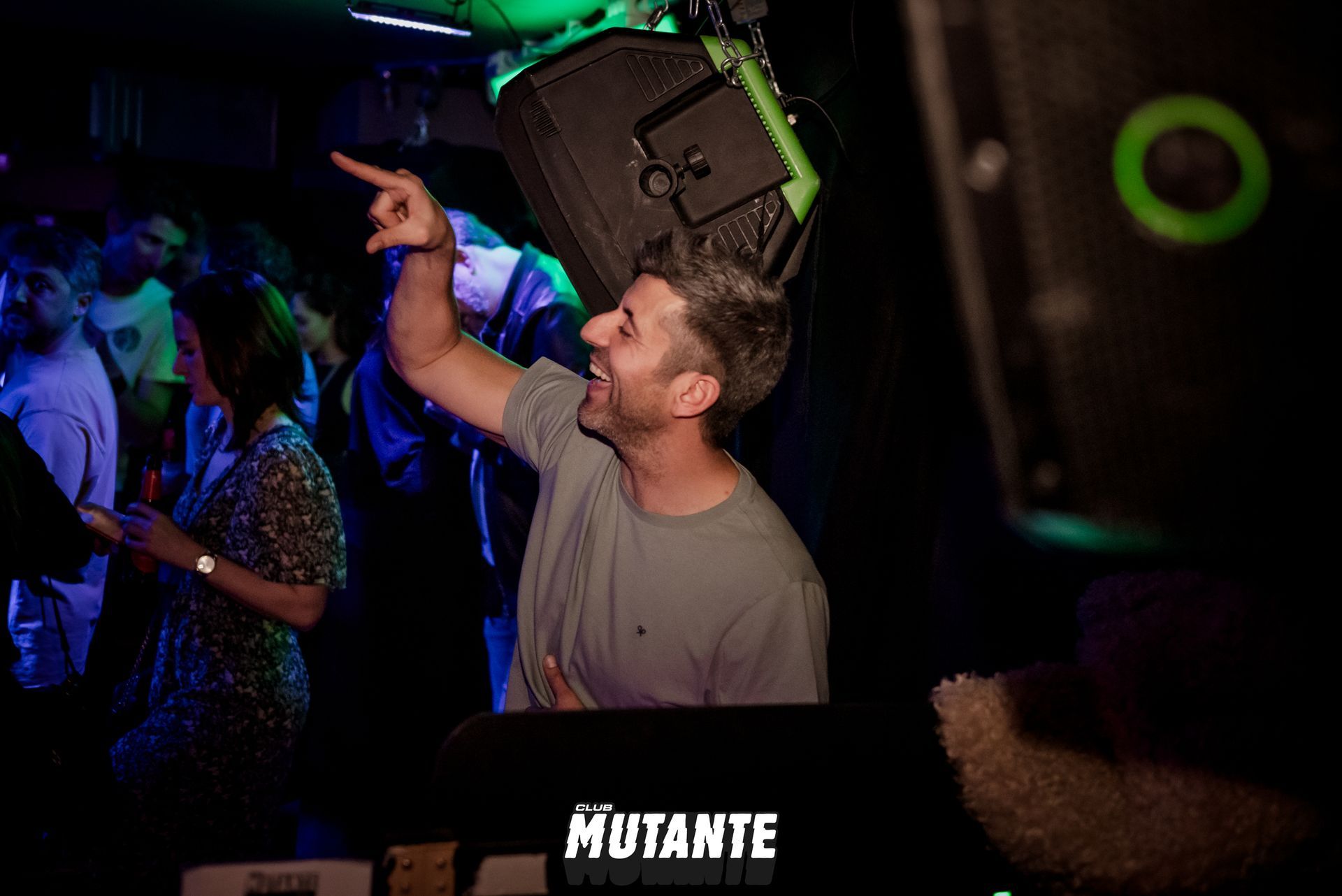 Un hombre señala a un altavoz en un club.