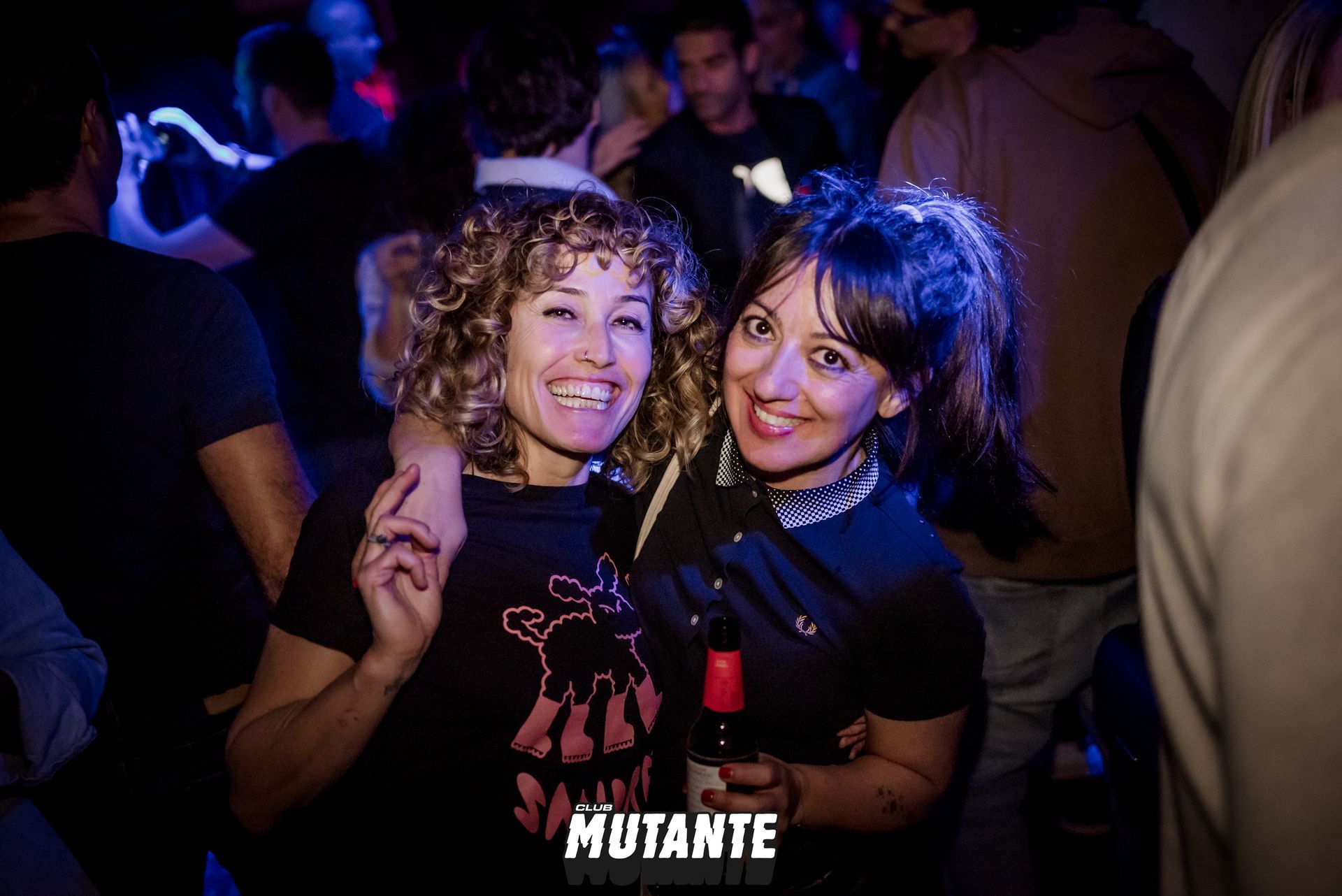 Dos mujeres posan para una fotografía en una fiesta.