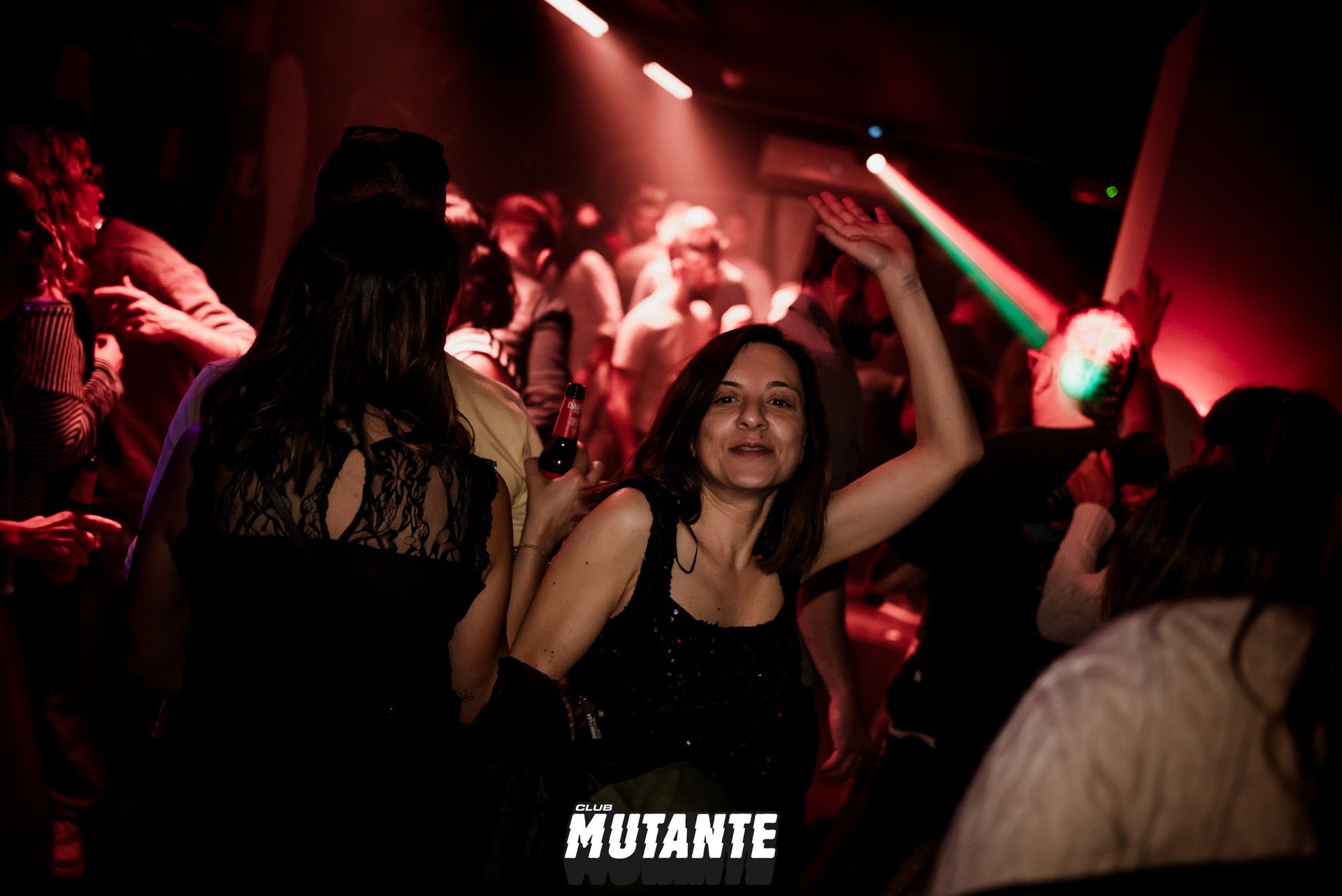 Una mujer está bailando en un club con la palabra mutante en la parte inferior.