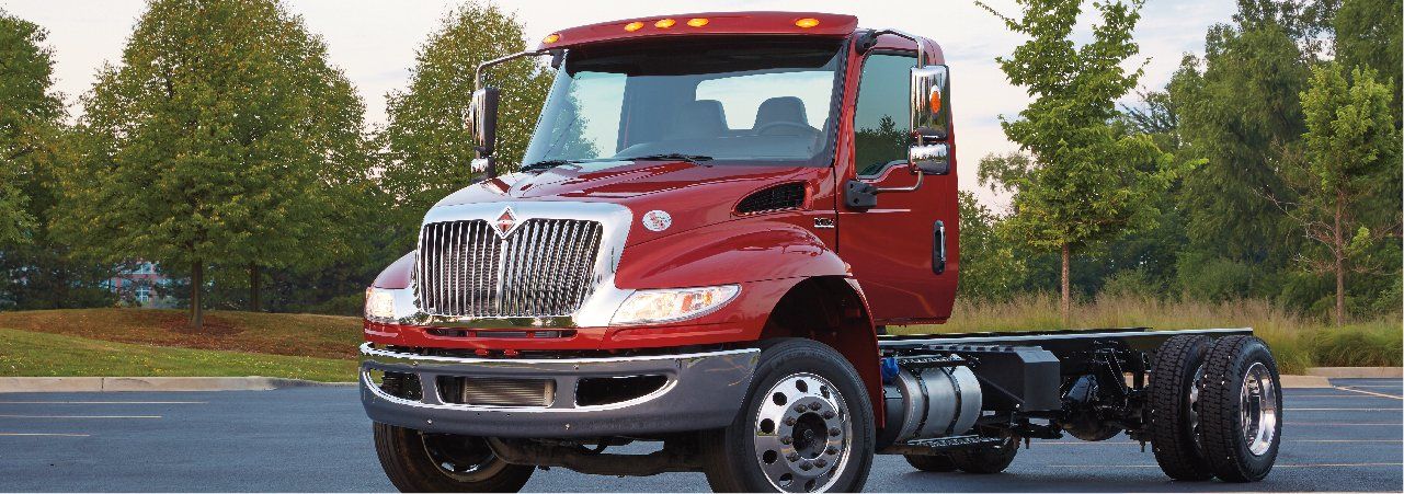 A red semi truck is parked on the side of the road.