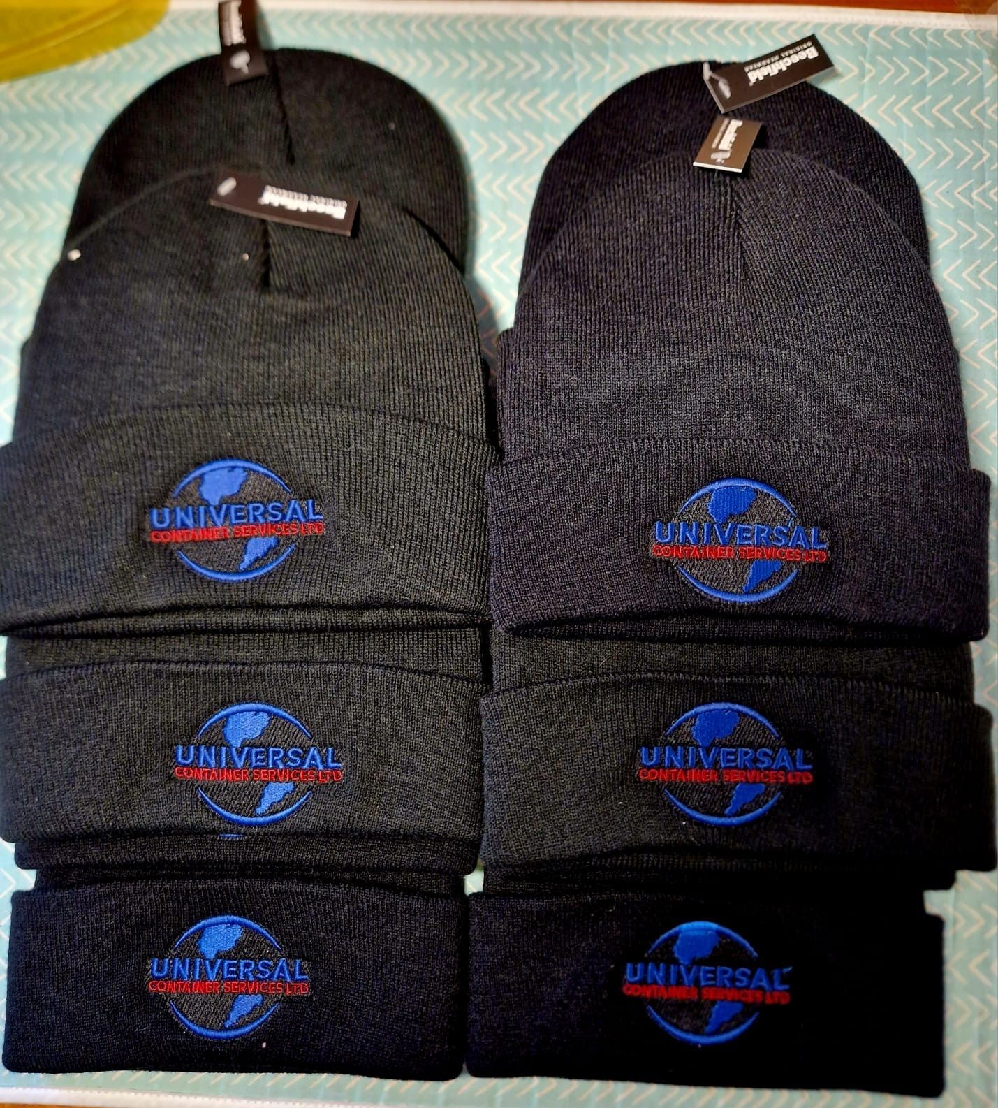Eight black beanies with the Universal Studios globe logo embroidered on the front.