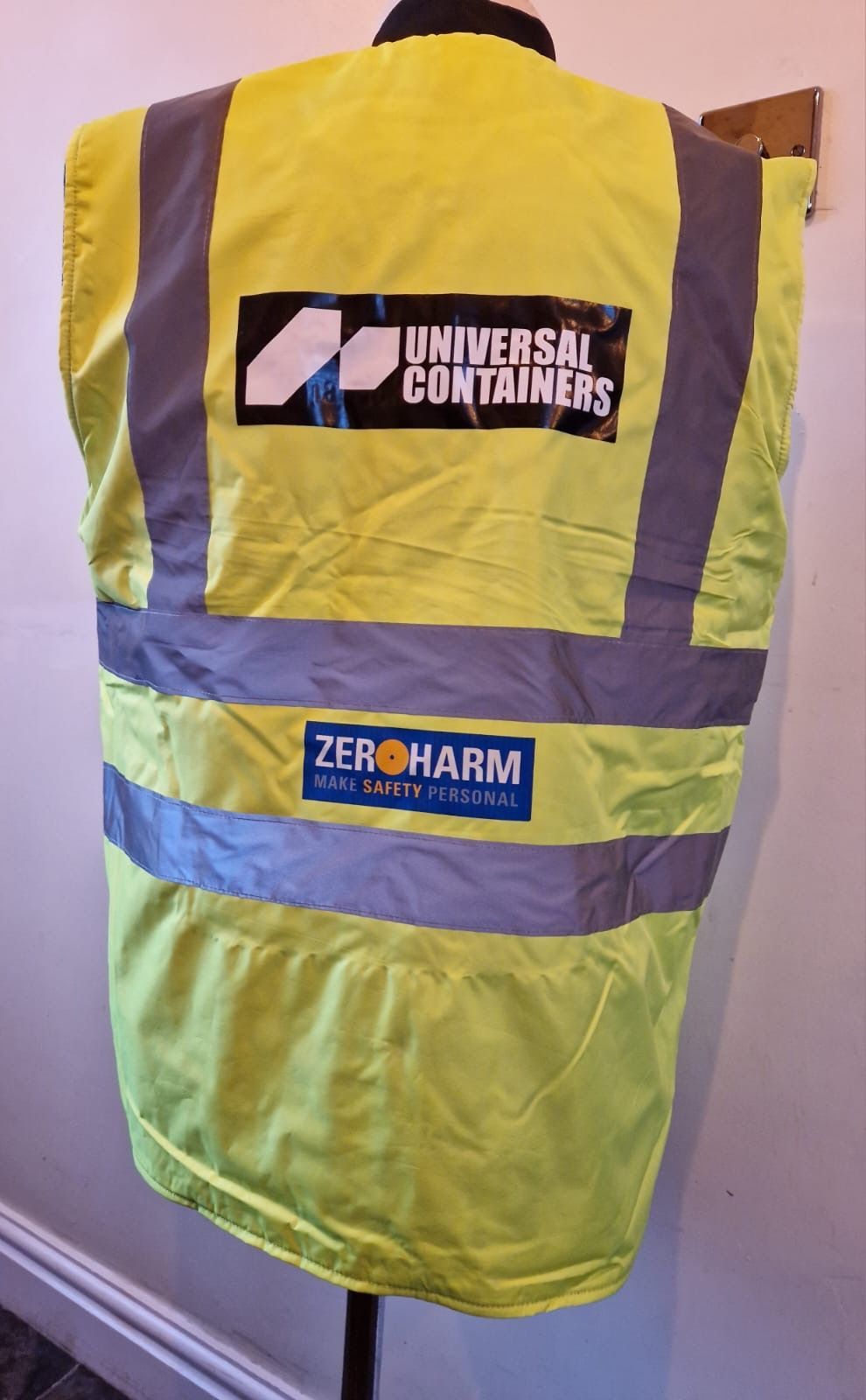 Yellow safety vest with reflective stripes and company logos: 