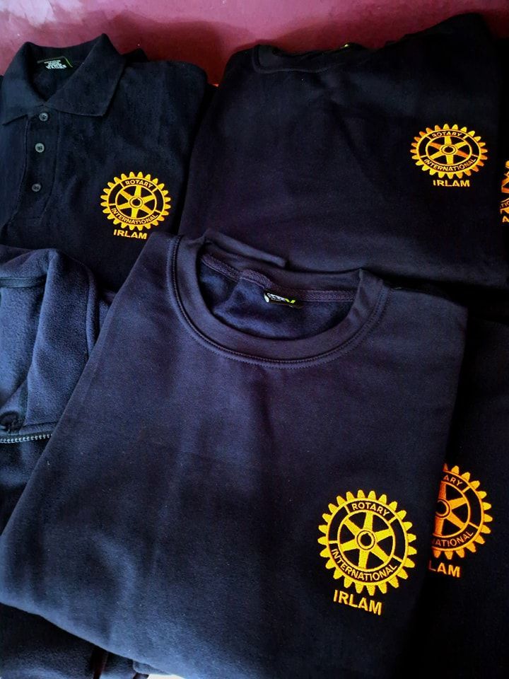 Navy blue shirts with gold Rotary International logo.