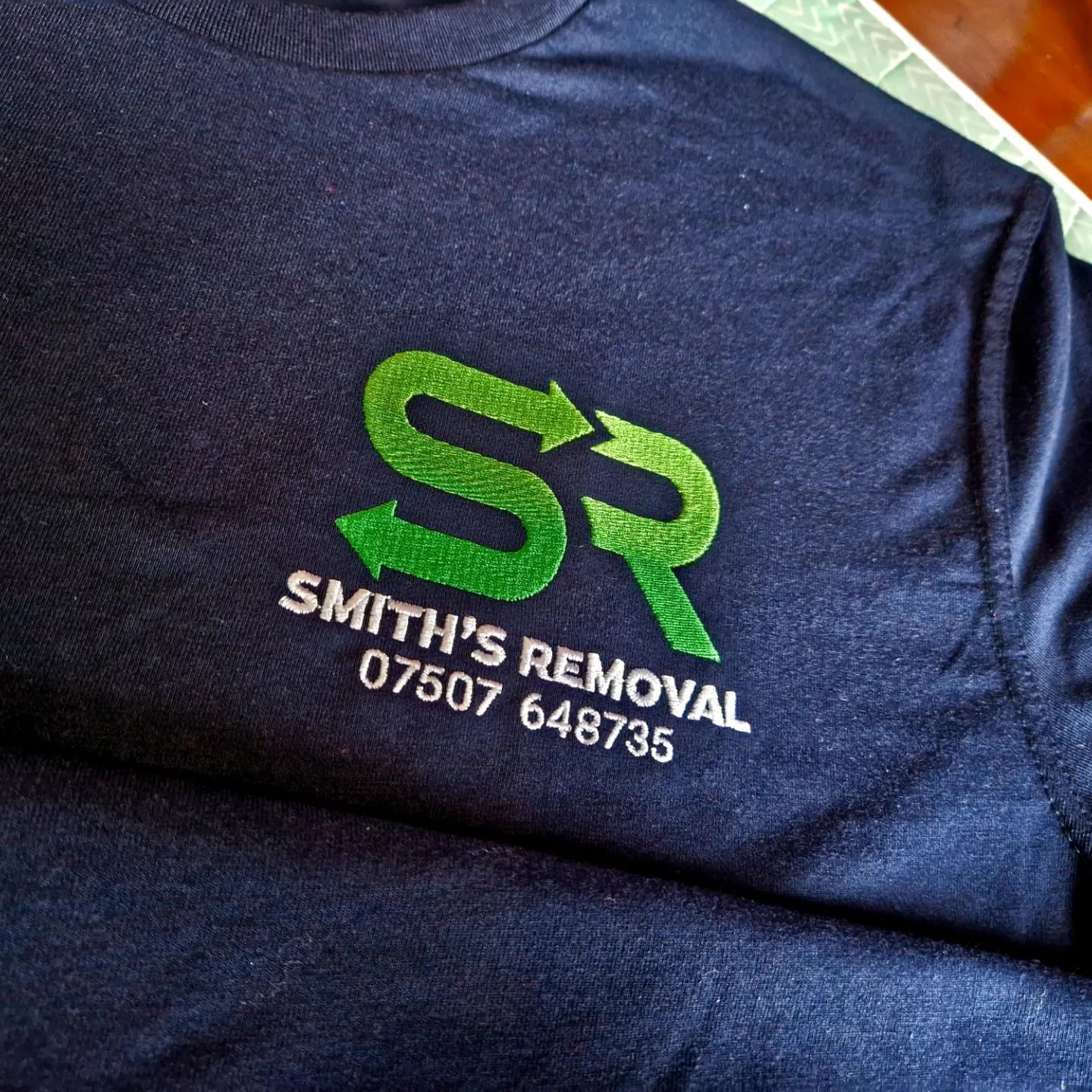 A smith 's removal t-shirt is laying on a table