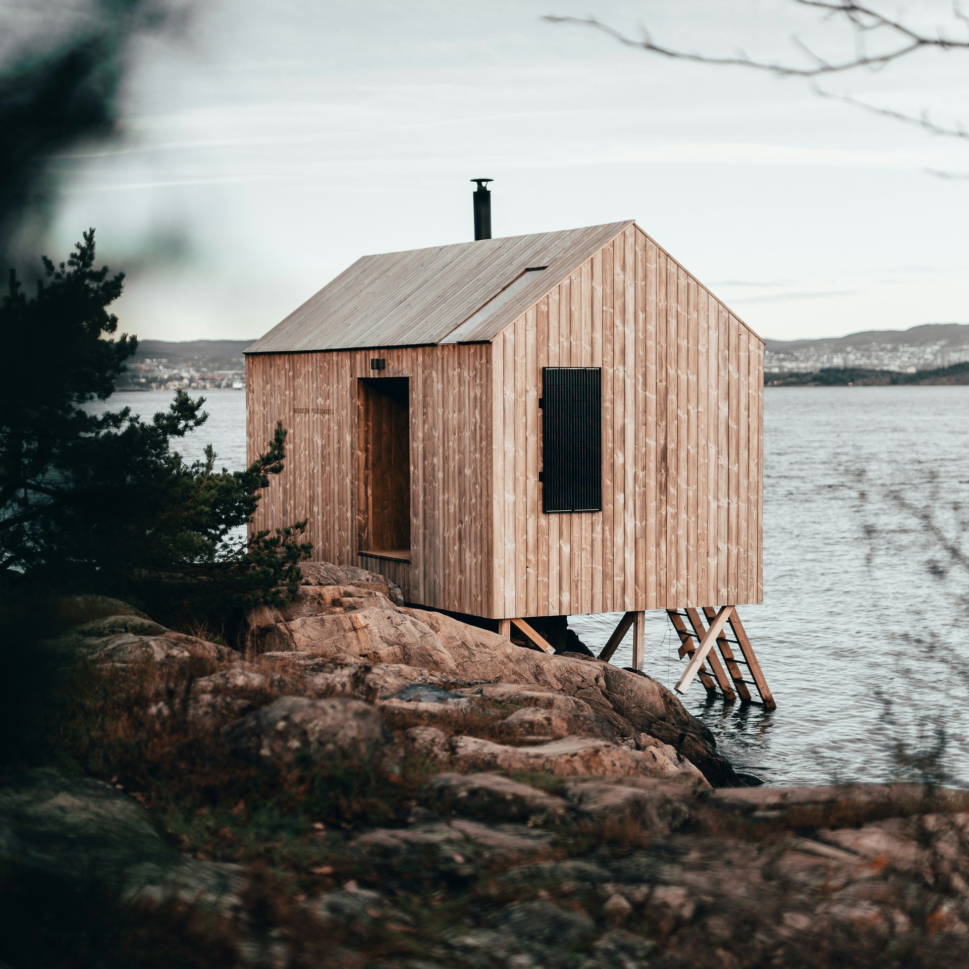 Maisemakuva järveltä, jossa mökki