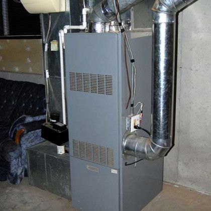 An air conditioner is sitting in a basement next to a couch