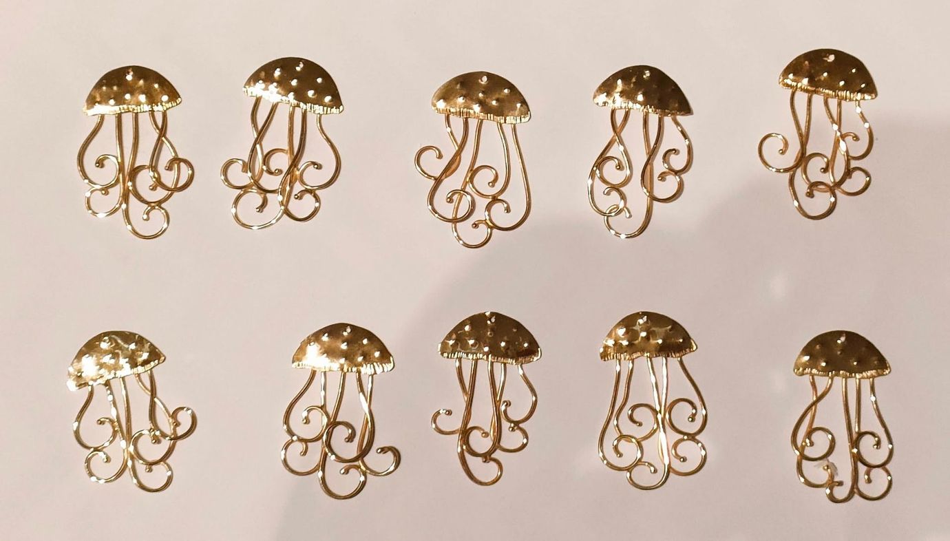 Fila di decorazioni dorate a forma di medusa su uno sfondo chiaro