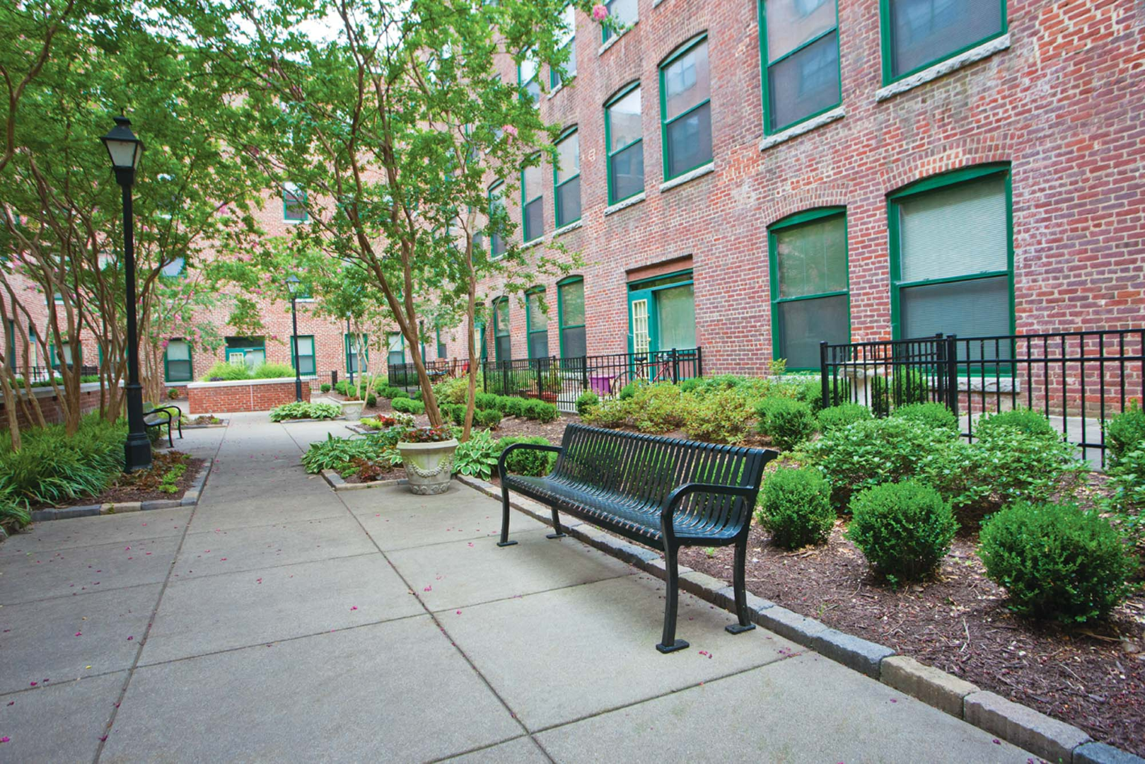 A brick building with a bench in front of it at The River Lofts at Tobacco Row offers apartments for rent in Richmond, VA.
