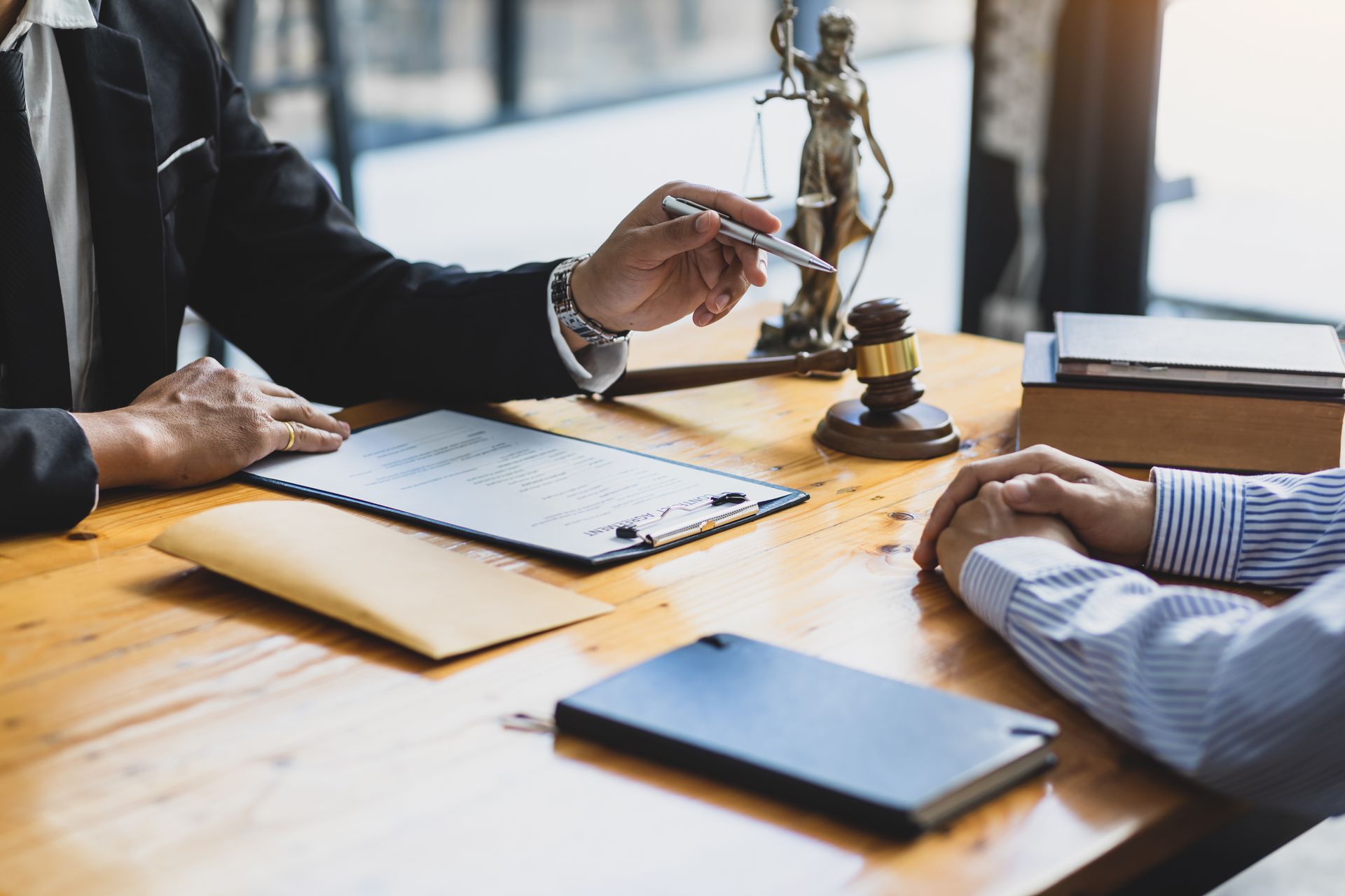 The criminal defense attorney meets with a client to review a legal case at the office.