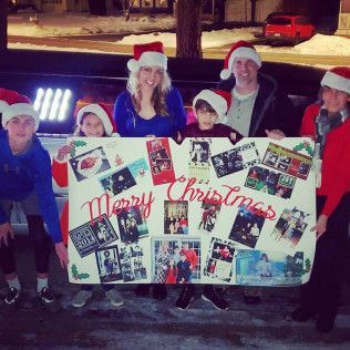 A family group wears Santa hats while holding a large 