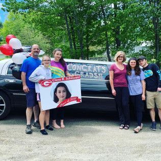 A group stands by a limousine decorated with balloons and a graduation sign for a student named Ciera.