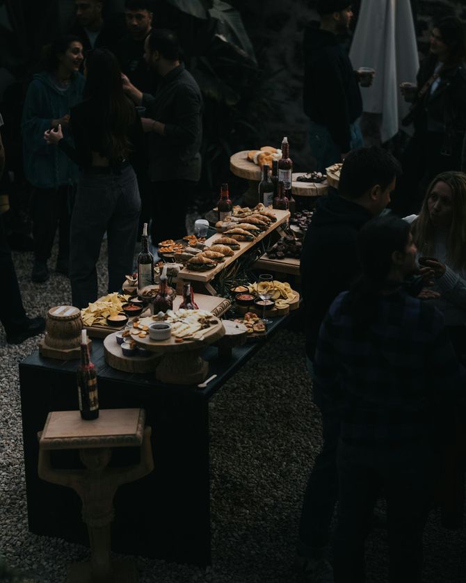 Buffet extérieur proposant un assortiment de plats et de boissons lors d'un événement nocturne très fréquenté.