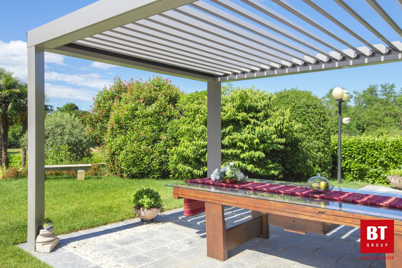 Un pergolato con un tavolo sottostante in un giardino.