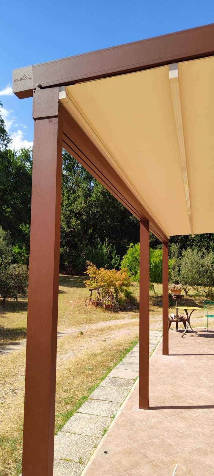 Un pergolato con tettoia è posto in cima a un patio.