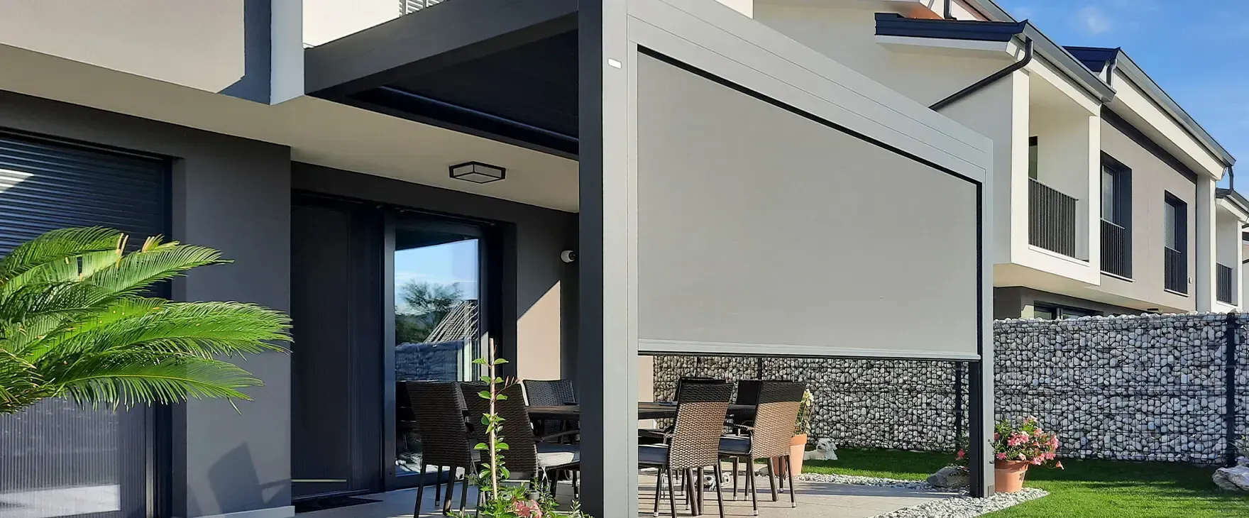 Una casa con un patio e un pergolato davanti.