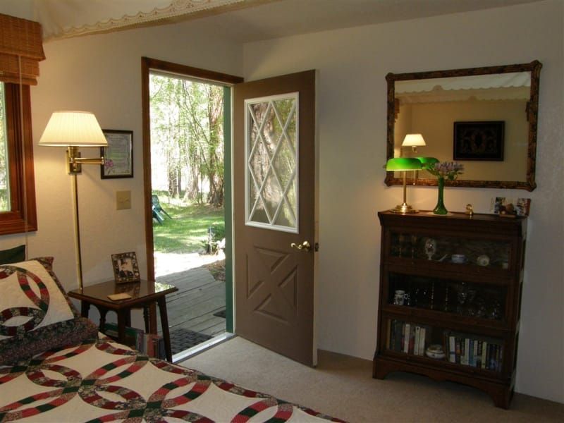 A bedroom with a bed and a mirror