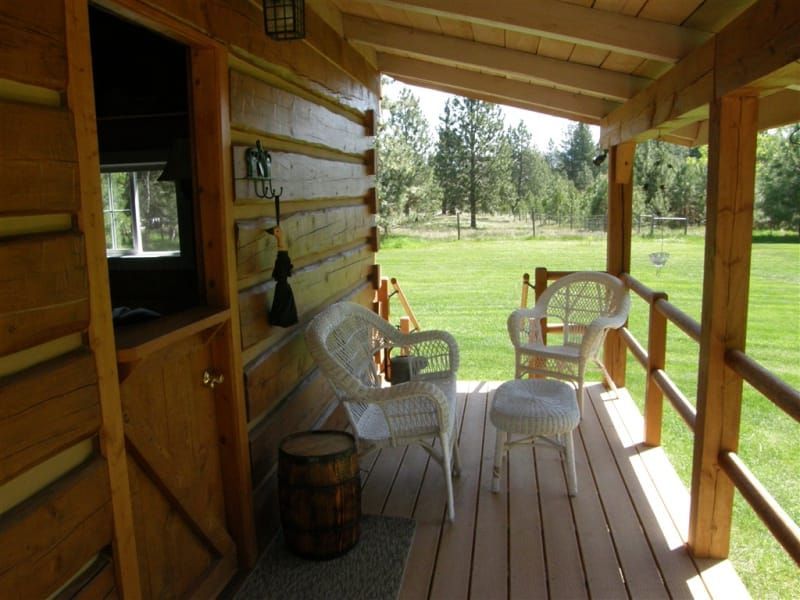 A porch with chairs and a barrel on it