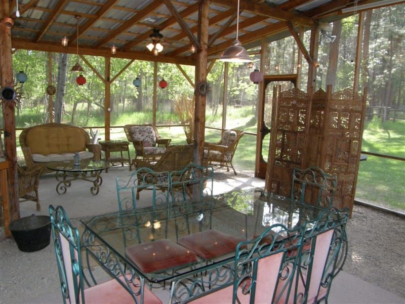 A screened in porch with a glass table and chairs