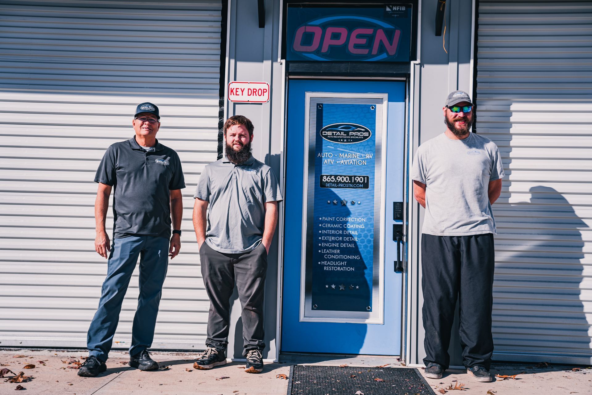 Three men stand outside a business with 