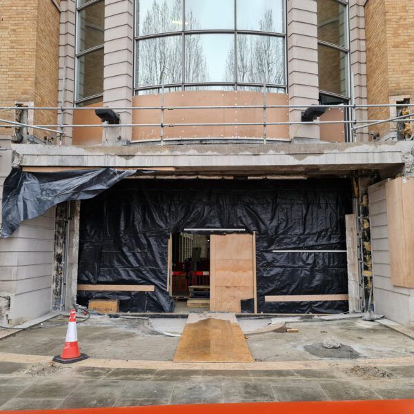 A building under construction with a cone in front of it