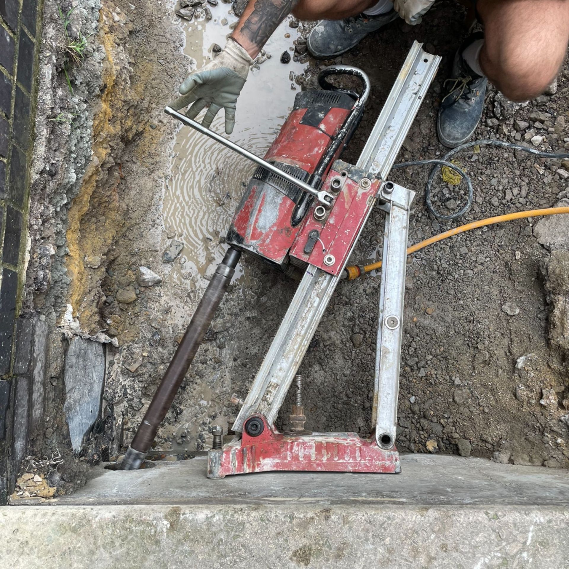 A person is using a machine to cut a hole in the ground