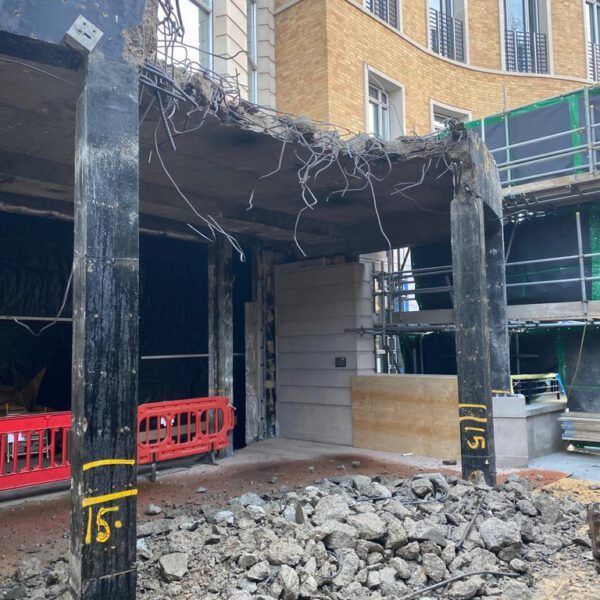 A building is being demolished and the number 15 is on a pole