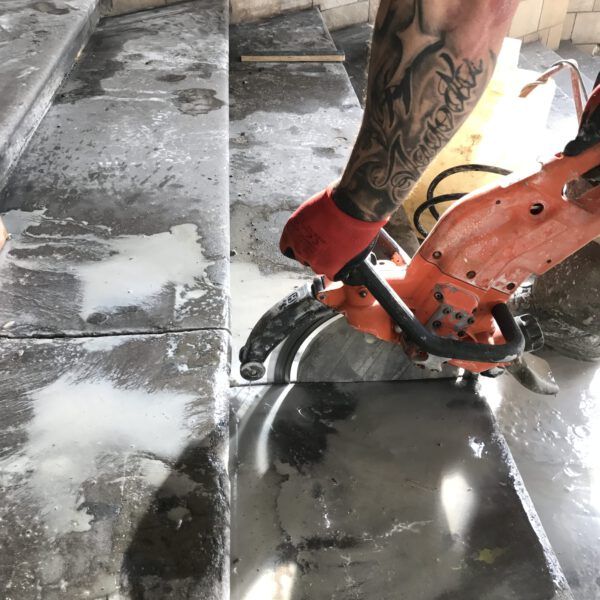 A person with a tattoo on their leg is using a circular saw