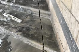 A close up of a person cleaning a staircase with a hose.