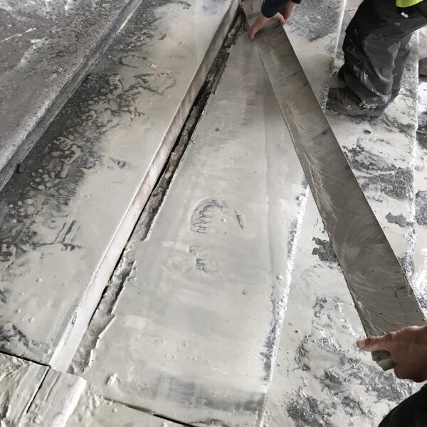 A person is cutting a piece of concrete with a saw.