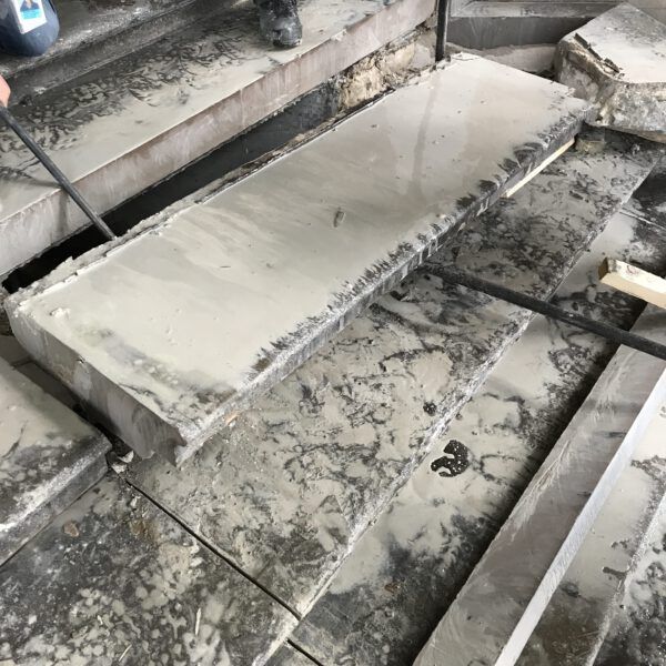 A person is working on a set of concrete stairs.