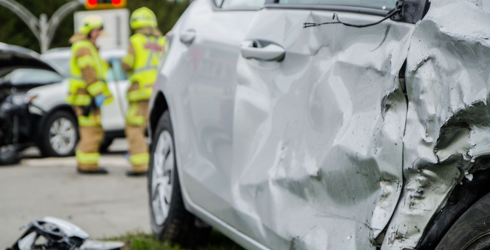 A car has been damaged in a car accident and is sitting in the grass.
