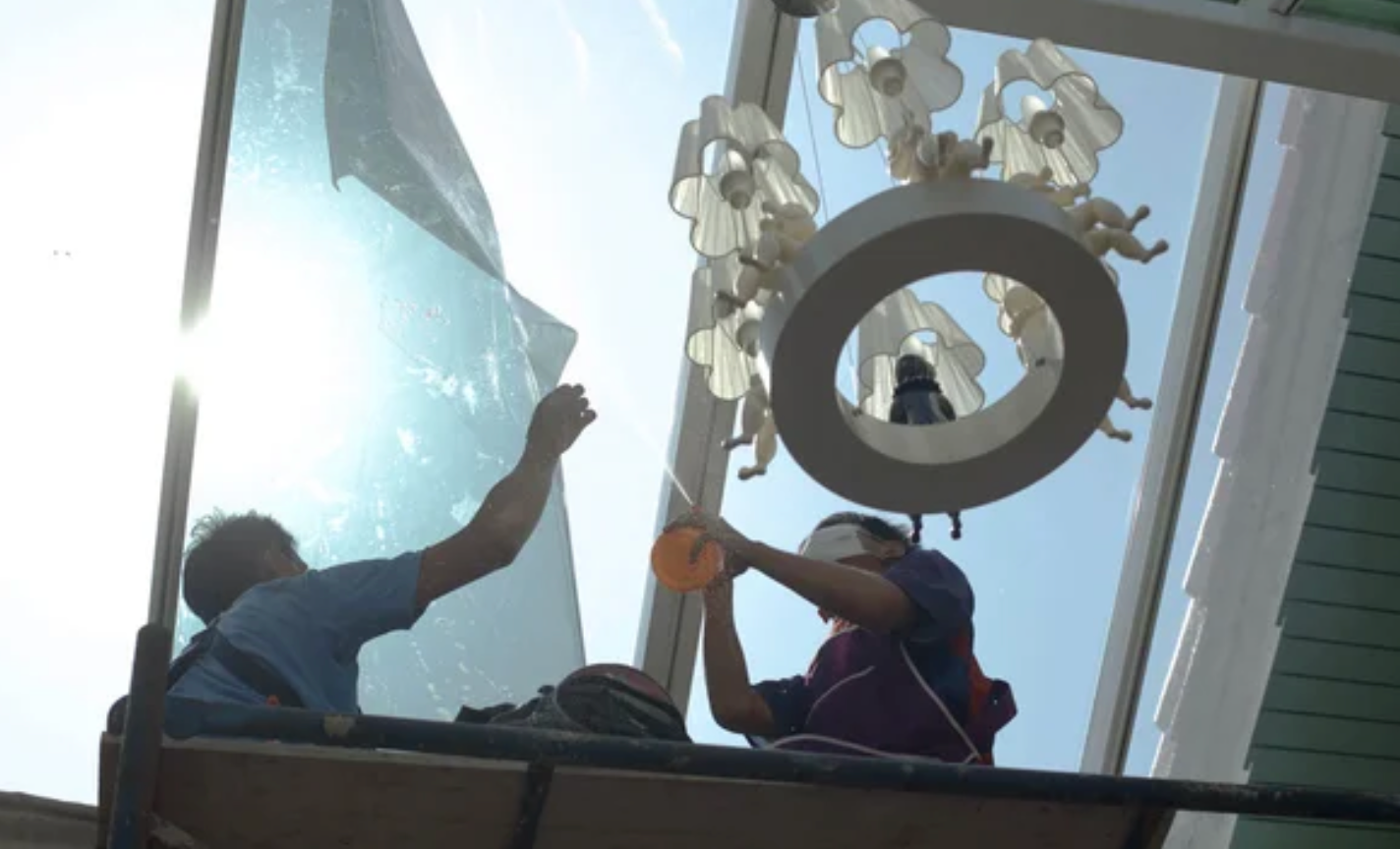 a logo of two men tinting a sun roof