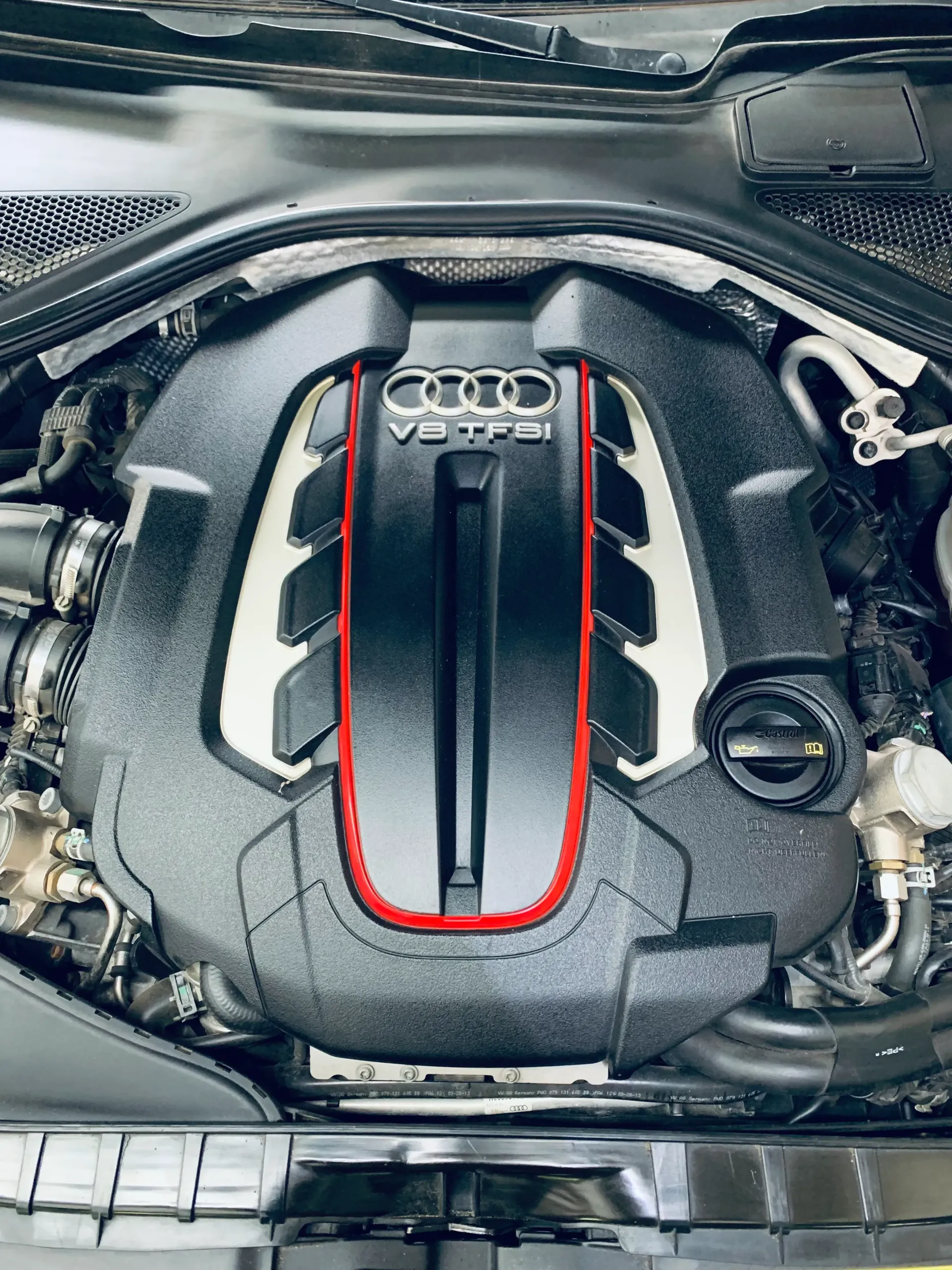 A close up of a car engine with the hood open.