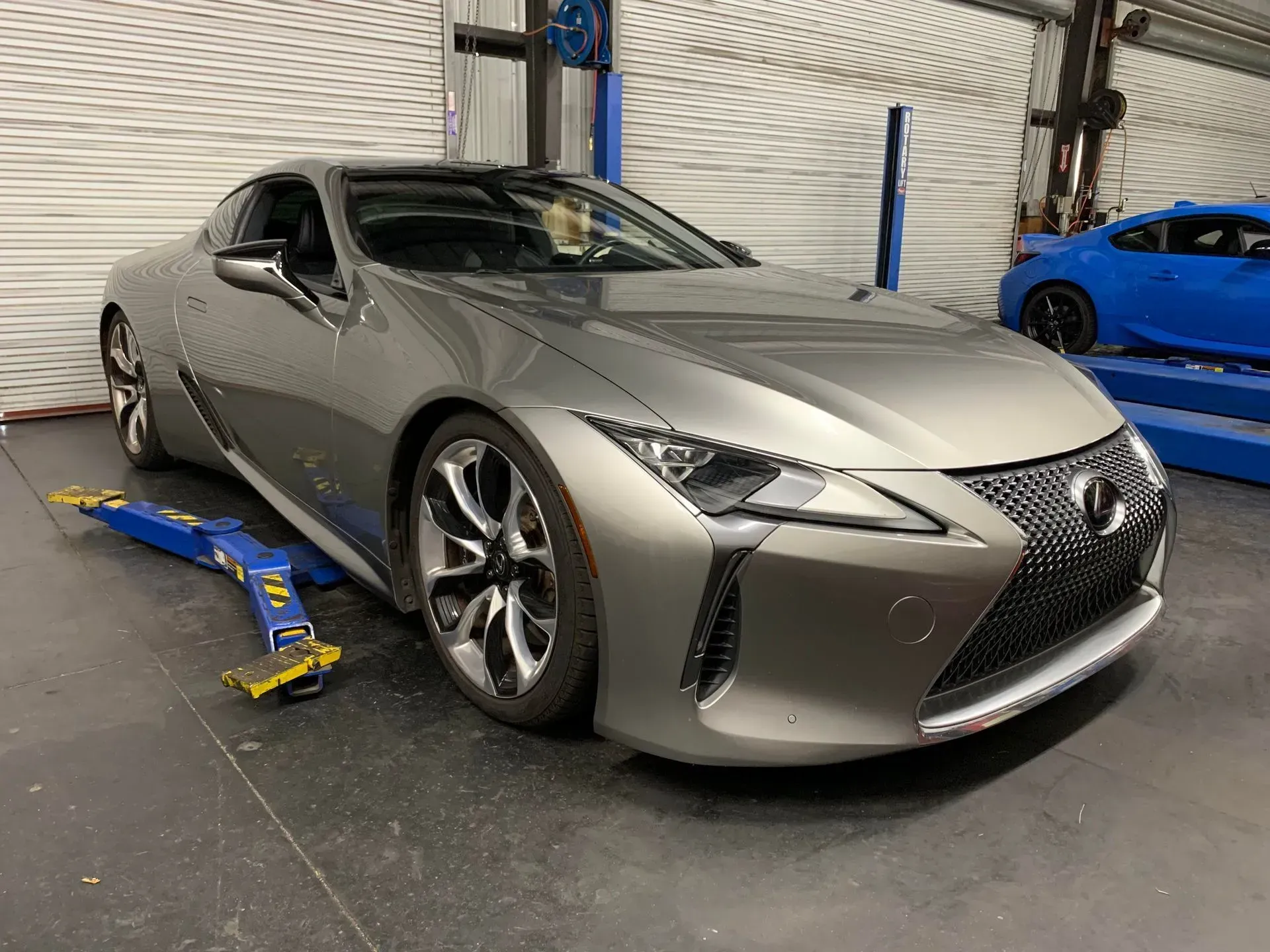 A woman is working on a car engine with a wrench.