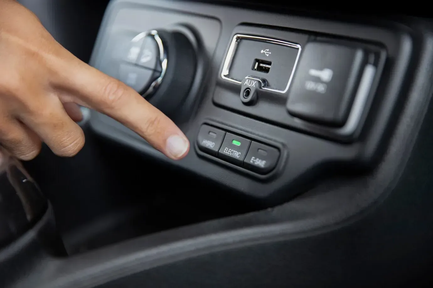 A person is pressing a button on a car dashboard.
